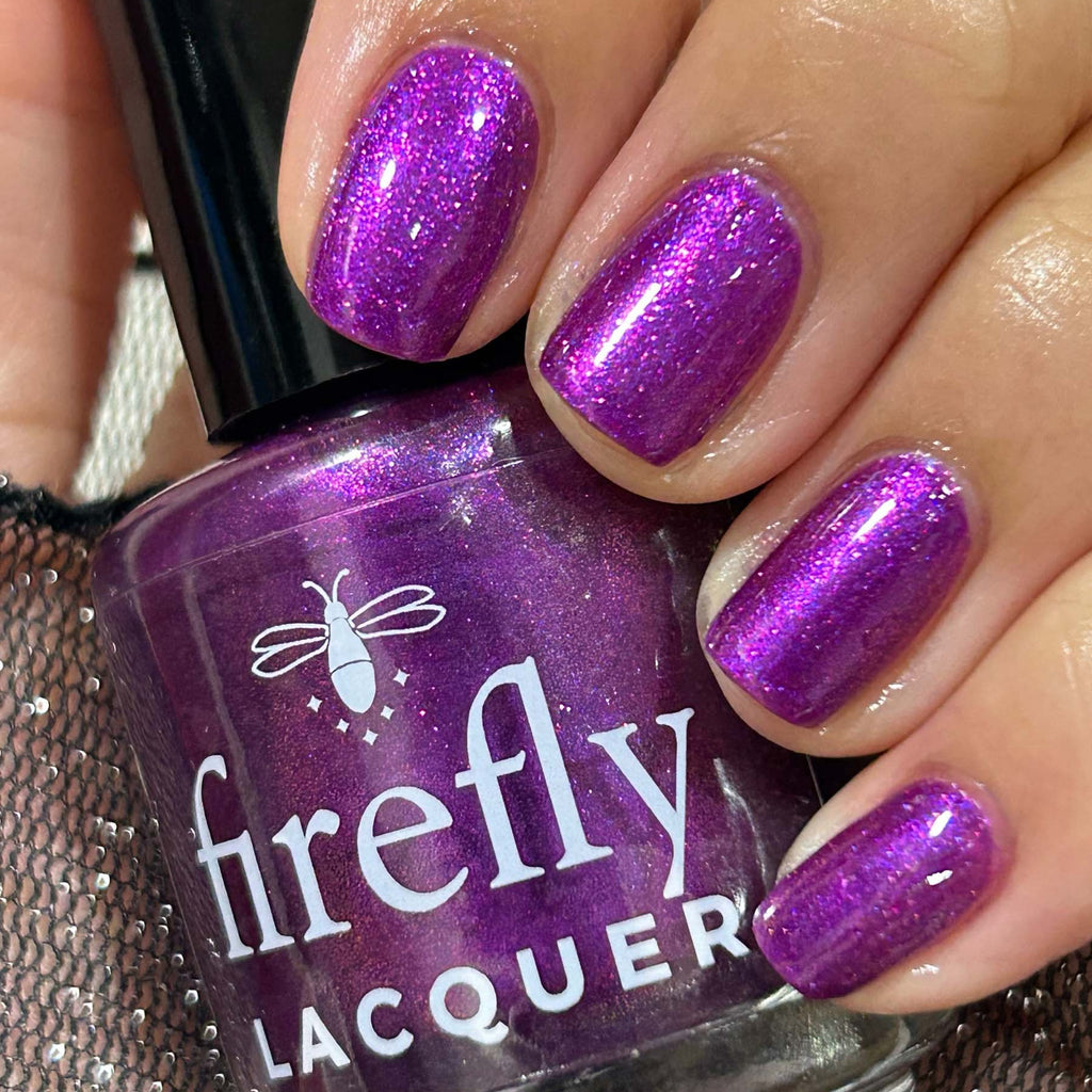 Purple glittery nails with a bottle of Firefly Lacquer nail polish.